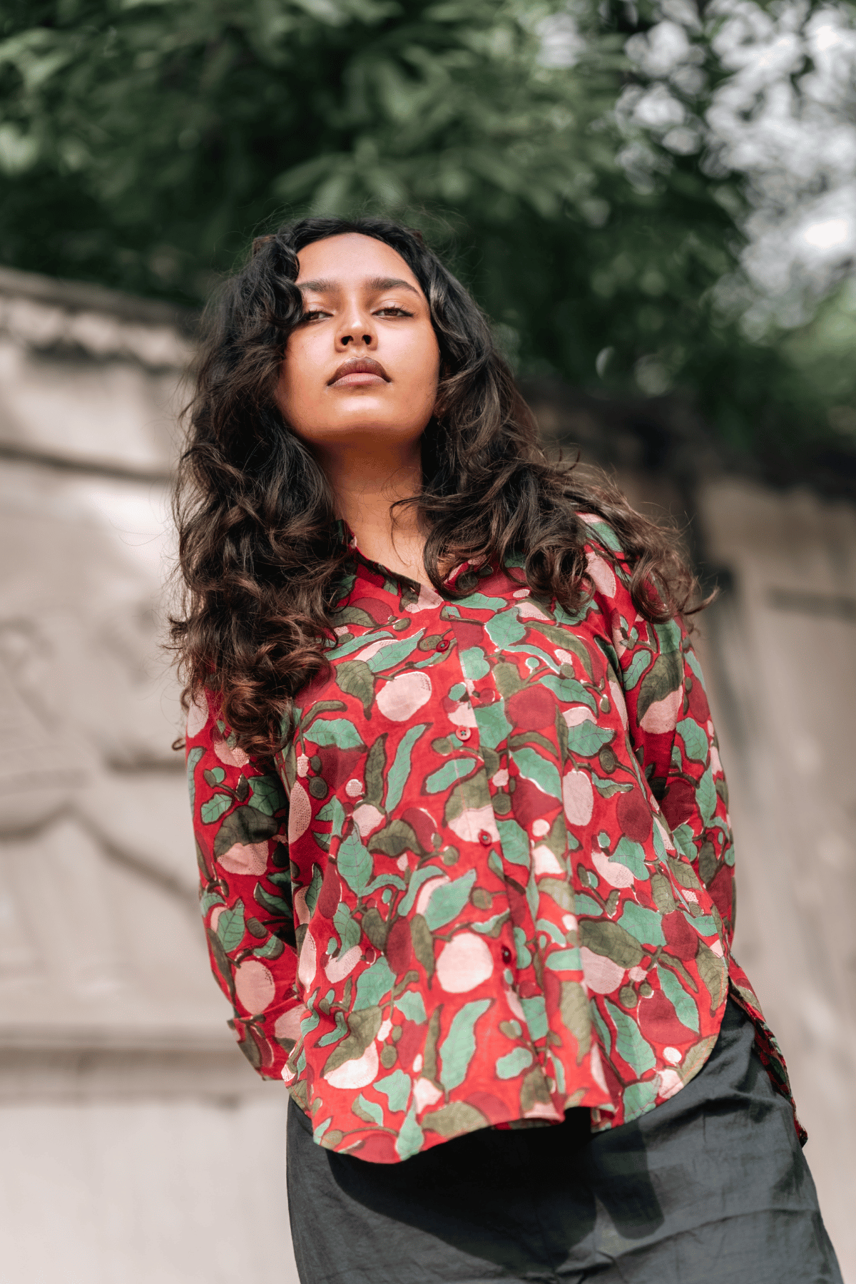 Woman wearing a red floral patterned shirt outdoors